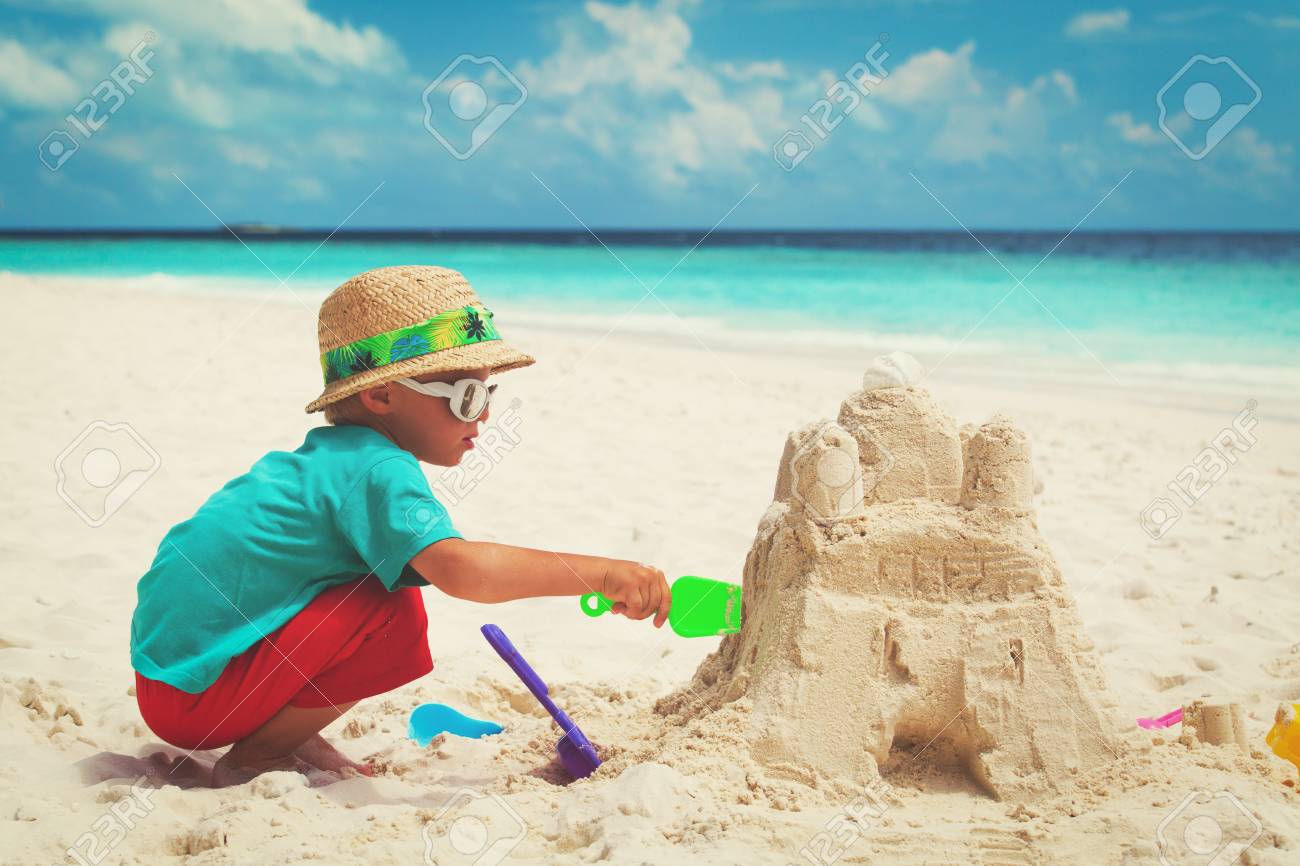 Little boy building sandcastles